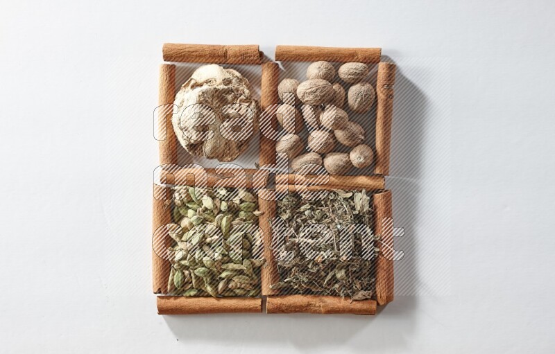 4 squares of cinnamon sticks full of nutmegs, dried ginger, cardamom and dried basil on white flooring