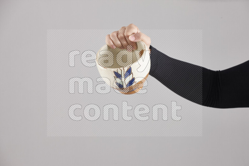 A woman in black abaya holding different pottery essentials in different positions