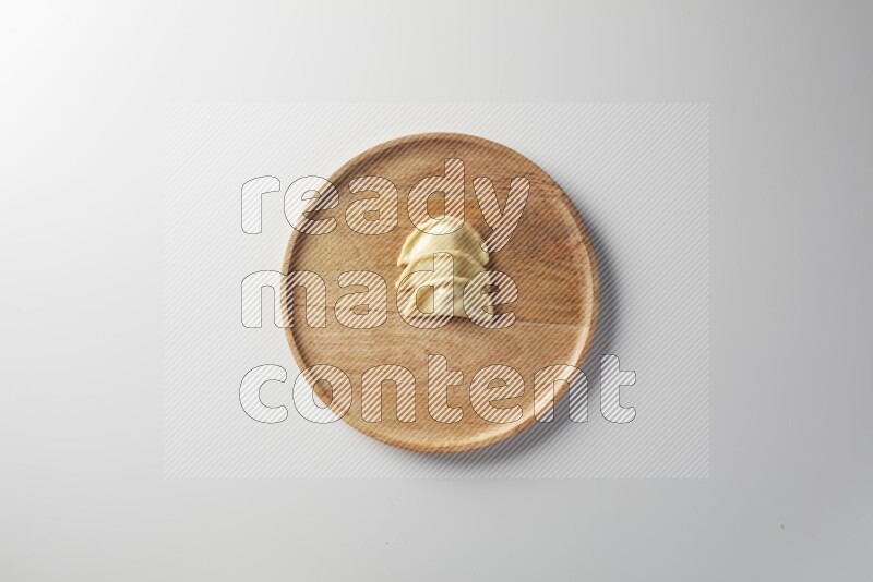 Three Sambosas on a wooden round plate on a white background