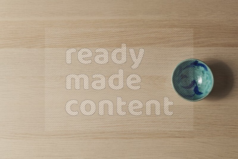 A decorative pottery bowl on light wooden background