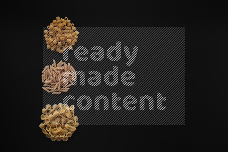 Different pasta types in 3 bunches on black background