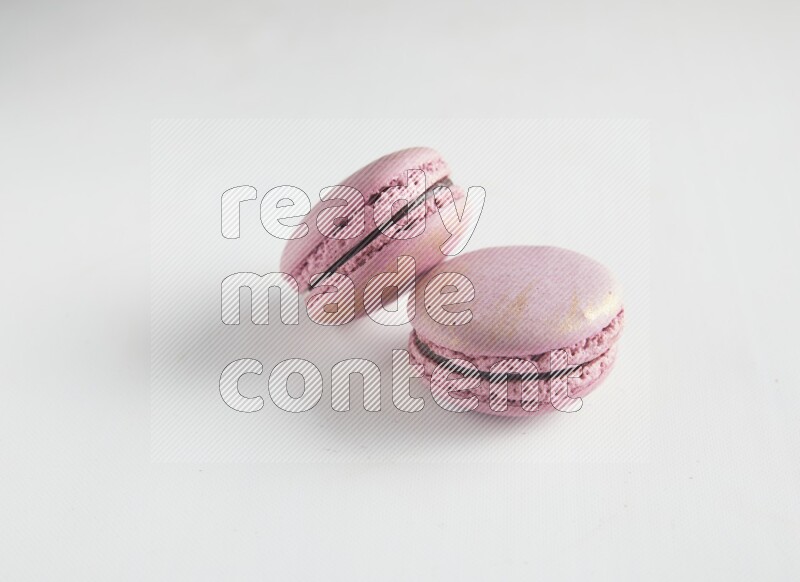 45º Shot of two Purple Strawberry macarons on white background