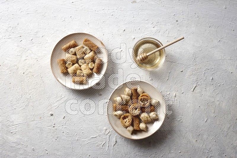 Oriental sweets in pottery plates with honey in a light setup