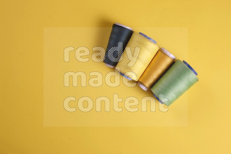 Green sewing supplies on yellow background
