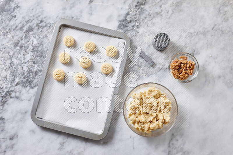 Kahk step by step with its ingredients ghee, sugar, flour, sesame, yeast, water and kahk flavor on grey marble background