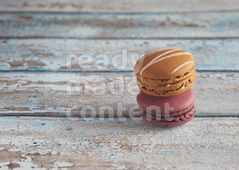 45º Shot of of two assorted Brown Irish Cream, and Red Cherry macarons  on light blue background