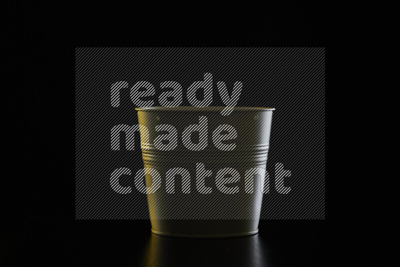 A plant pot with colored rim light against black background