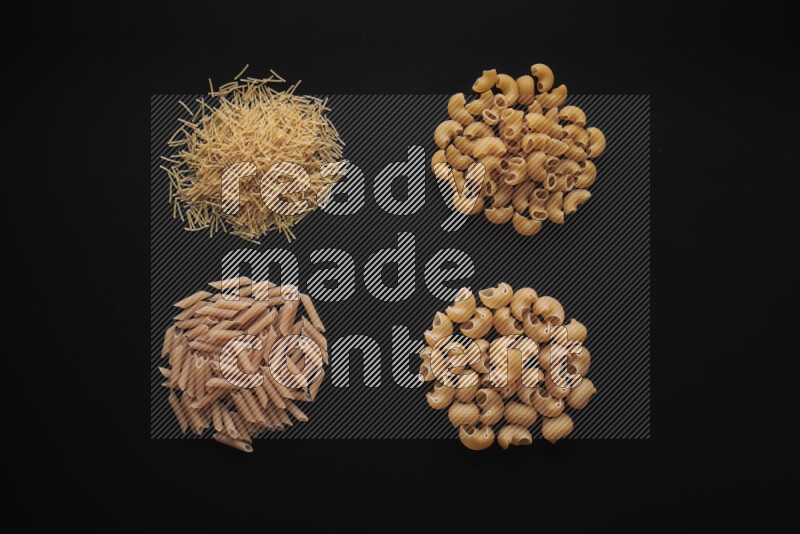 Different pasta types in bunches on black background