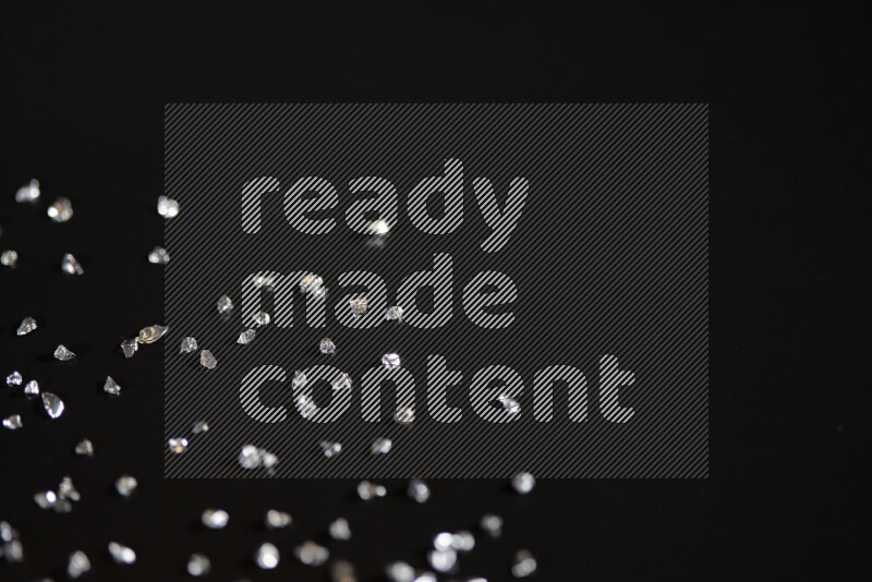 قطع زجاجية فضية لامعة متناثرة على خلفية سوداء