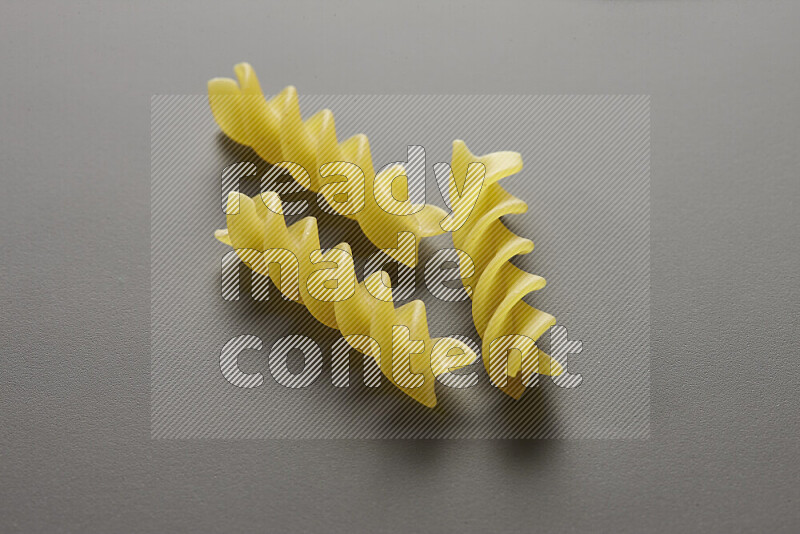 Fusilli pasta on grey background