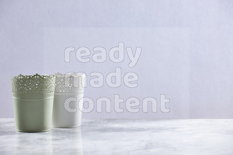 Empty green and white plant pots on grey marble background