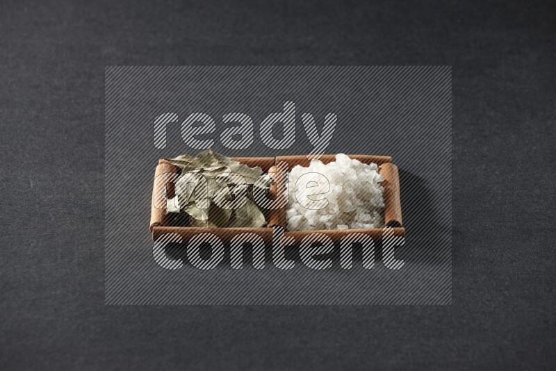 2 squares of cinnamon sticks full of salt and bay laurel on black flooring