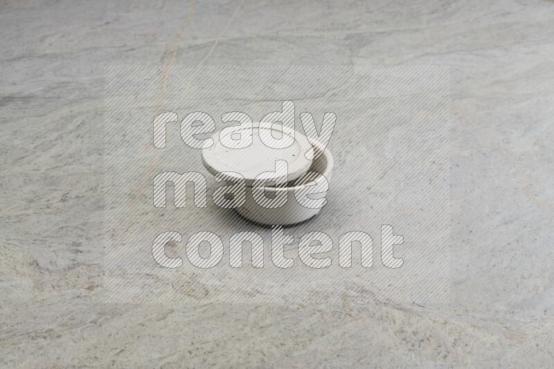 A white pottery bowl on grey marble background