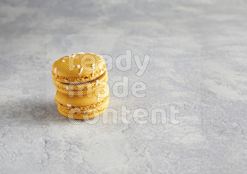 45º Shot of two Yellow Piña Colada macarons  on white  marble background