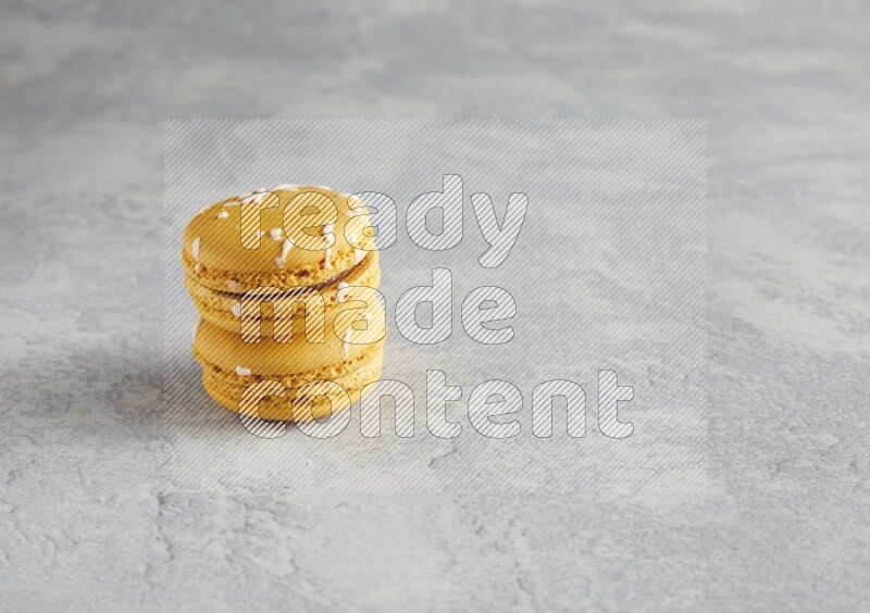 45º Shot of two Yellow Piña Colada macarons  on white  marble background