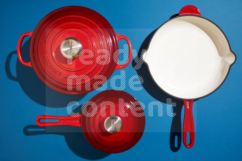 red and white pan and pot on blue background