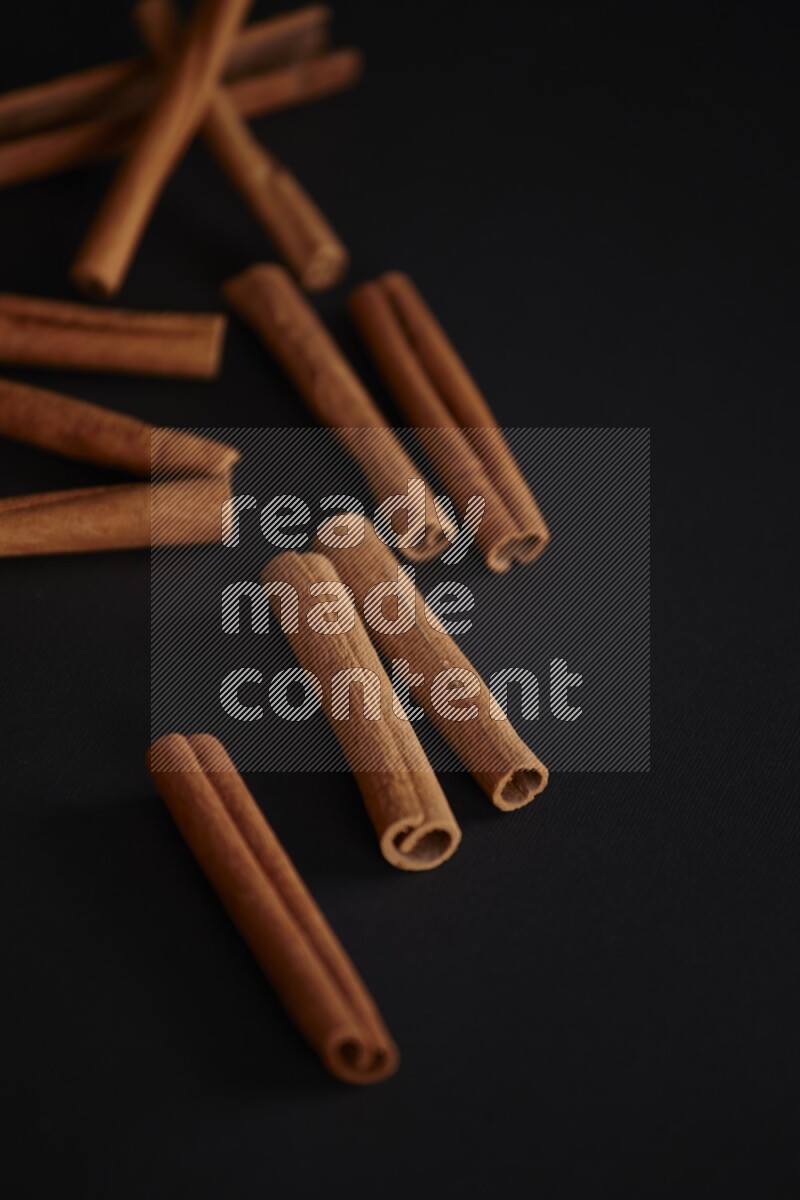 Cinnamon sticks stacked on black flooring
