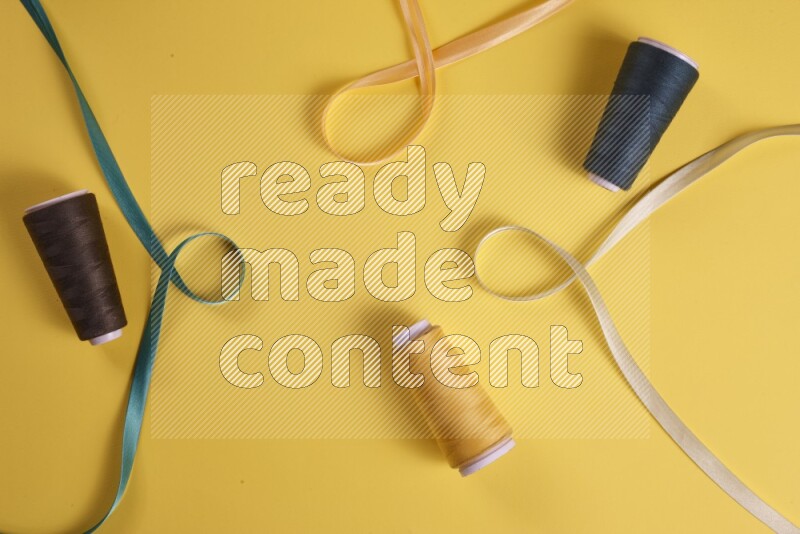 مجموعة من أدوات الخياطة والتفصيل خضراء اللون على خلفية صفراء