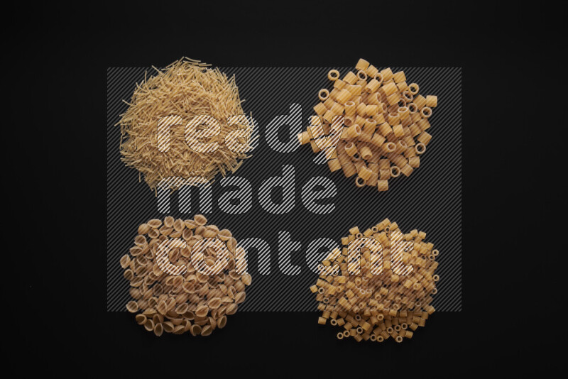 Different pasta types in bunches on black background