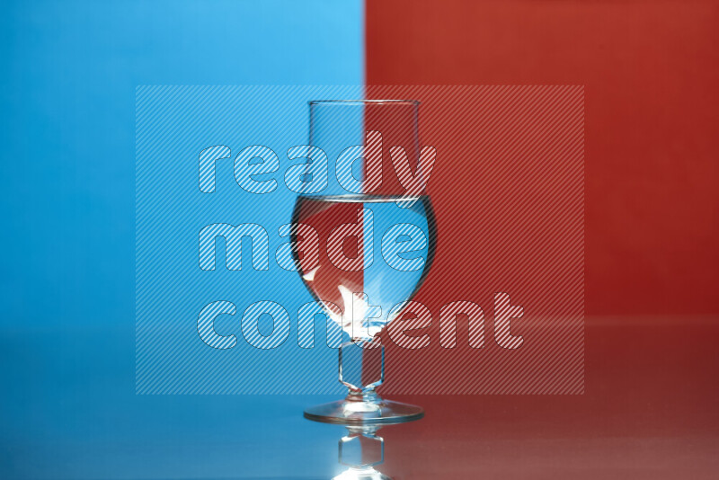 The image features a clear glassware filled with water, set against blue and red background