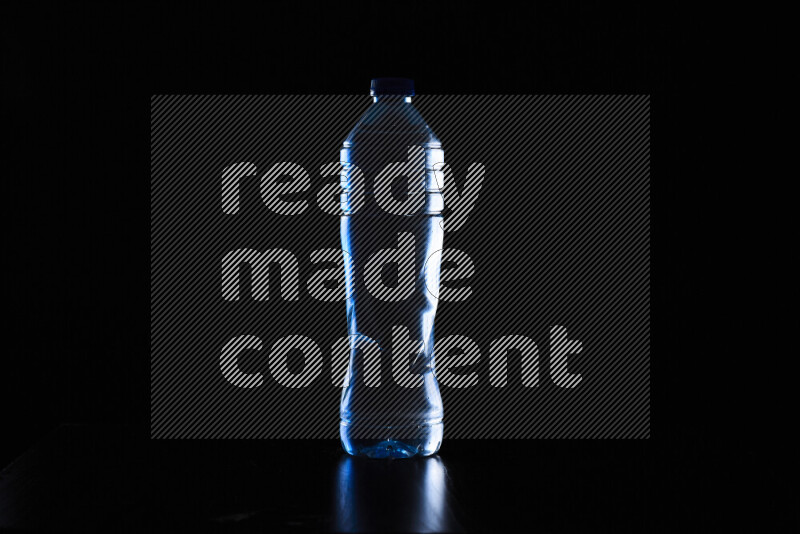 Water bottle with colored rim light against black background