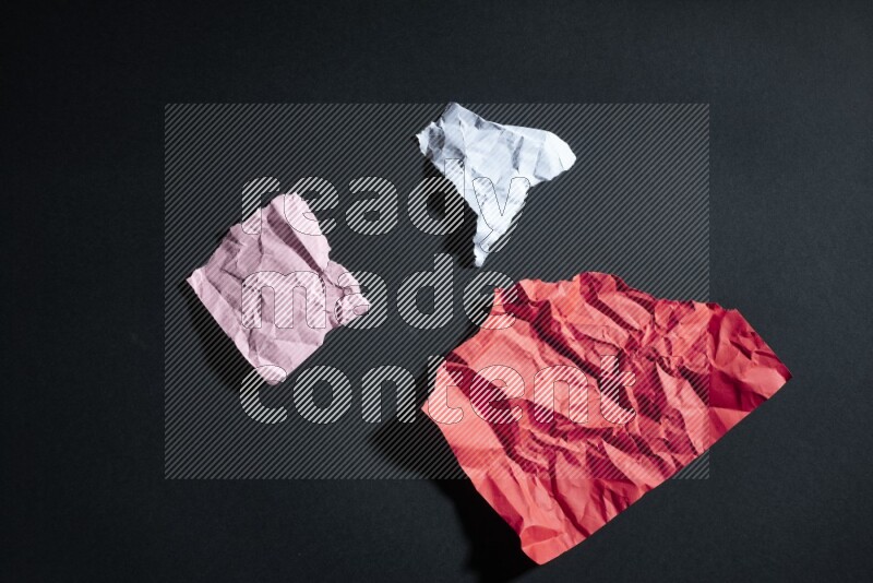 Crumpled multicolored paper on black background