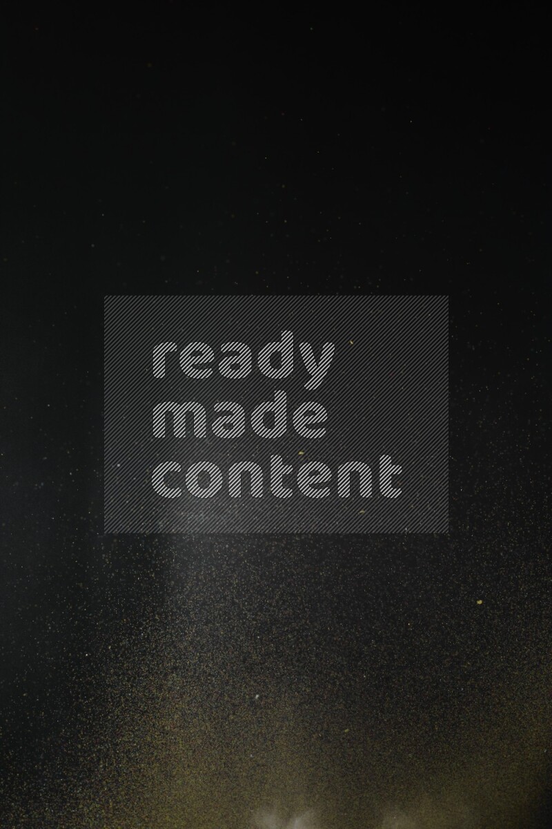 A side view of brown powder explosion on black background