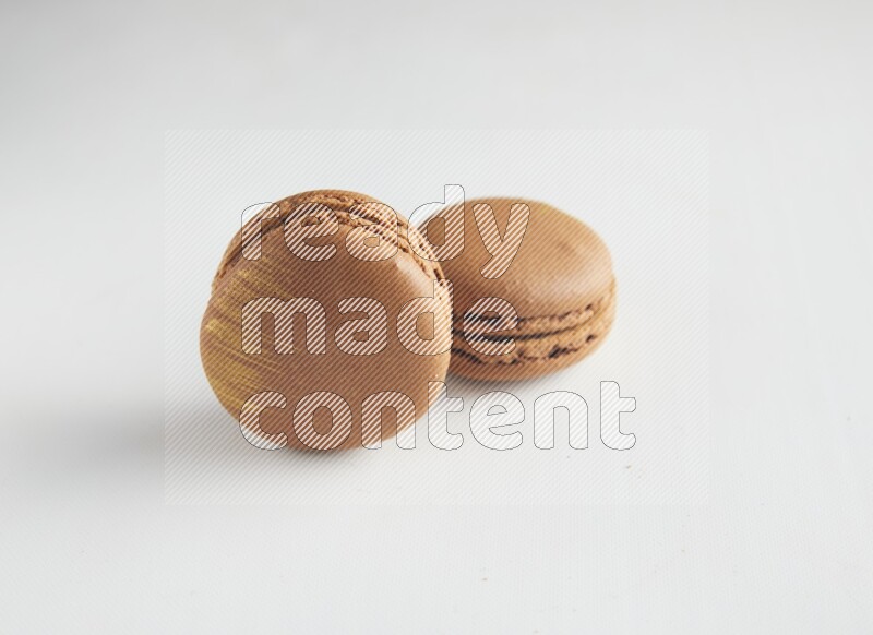 45º Shot of two Brown Coffee macarons on white background