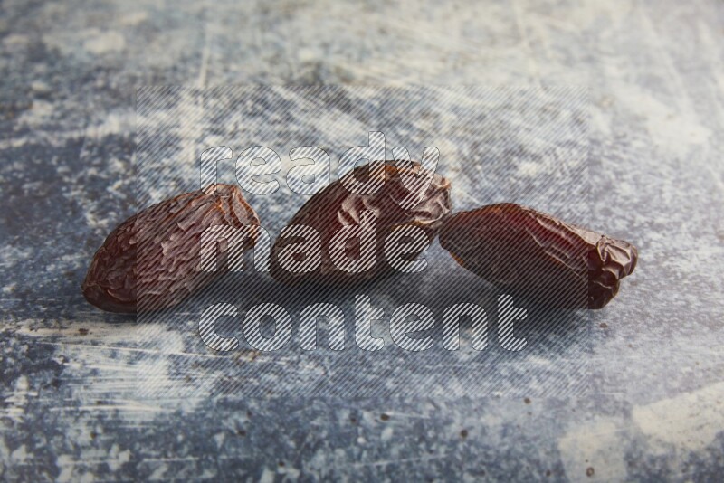 three madjoul dates on a rustic blue backround