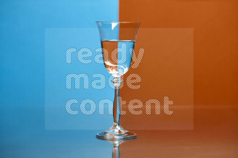 The image features a clear glassware filled with water, set against blue and dark orange background