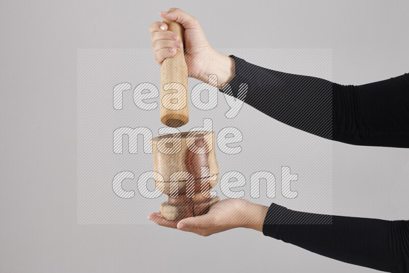 A woman in black abaya holding different wooden essentials in different positions