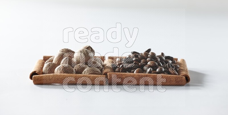 2 squares of cinnamon sticks full of coffee beans and nutmegs on white flooring