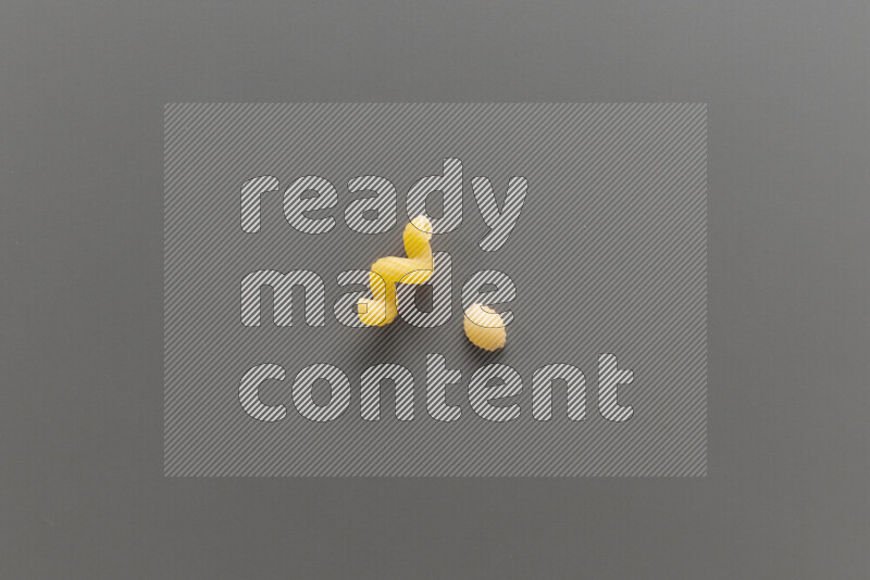 Twist pasta with other types of pasta on grey background
