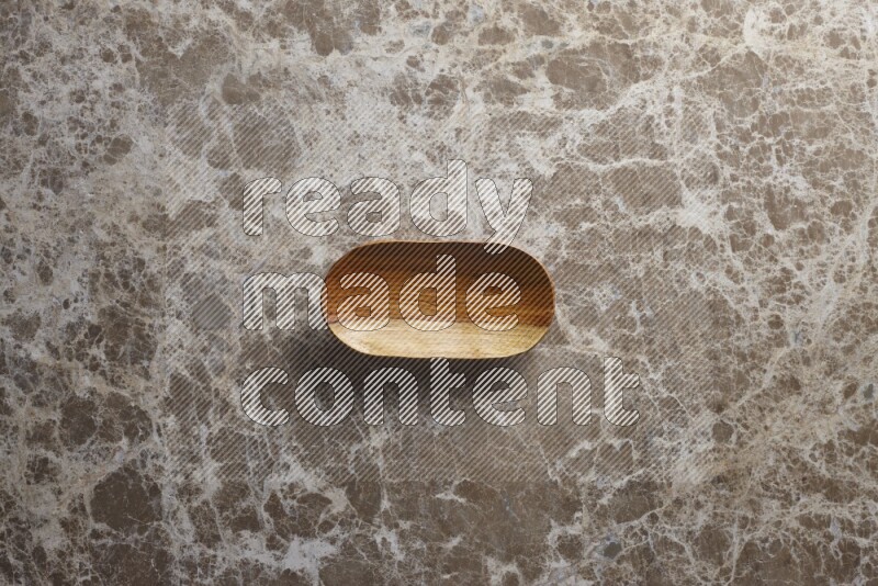 A wooden plate on beige marble background