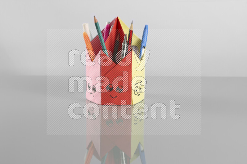 Origami pen holder on grey background