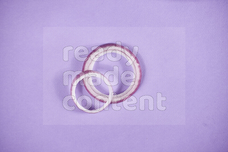 Red onions rings on purple background