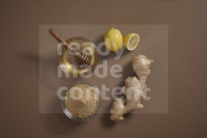 Fresh ginger root with different ingredients such as lemon, orange, honey, ground ginger on beige baackground