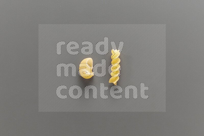 Pipe pasta with other types of pasta on grey background