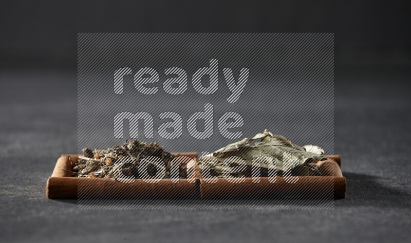 2 squares of cinnamon sticks full of bay laurel leaves and dried basil on black flooring