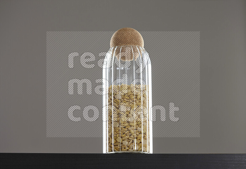 Crushed beans in a glass jar on black background