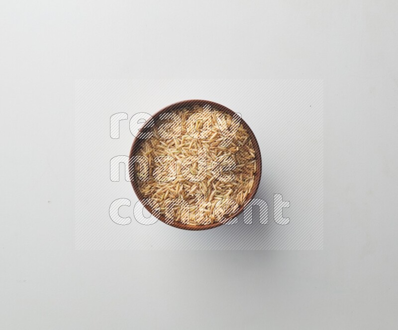 Top-view shot of long grain brown rice in a container on white background