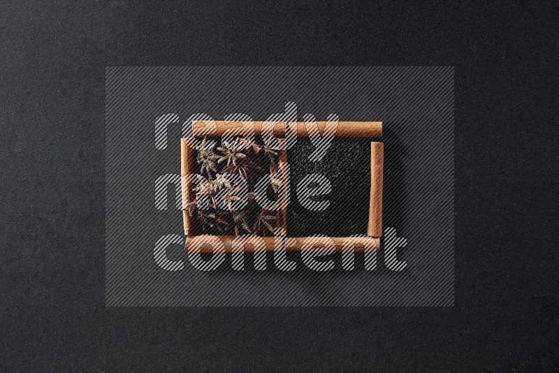 2 squares of cinnamon sticks full of black seeds and star anise on black flooring