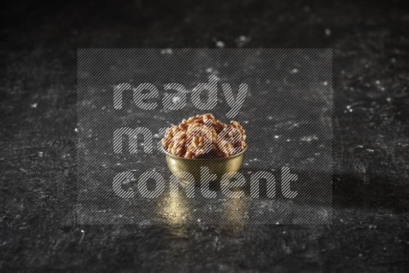 Nuts in a metal bowl in a dark setup