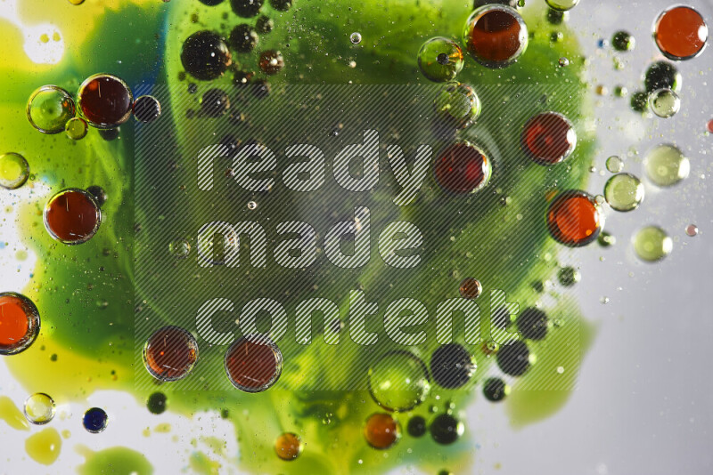 لقطات مقربة لقطرات ألوان مائية حمراء وزرقاء وصفراء وخضراء على سطح الزيت على خلفية بيضاء