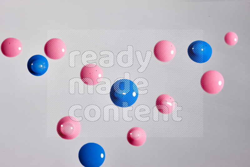 Close-ups of abstract pink and blue paint droplets on the surface