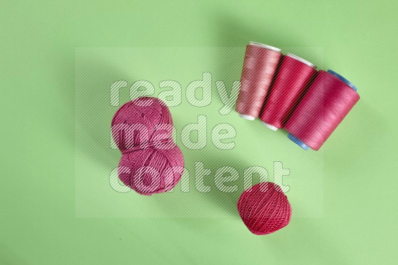 Pink sewing supplies on green background