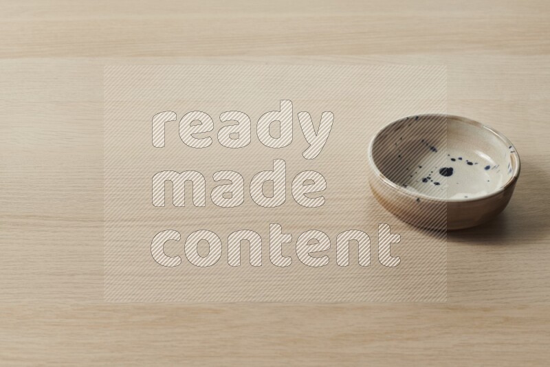 A multicolored pottery plate on light wooden background