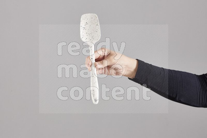 امرأة ترتدي عباءة سوداء تحمل أدوات خشبية مختلفة في أوضاع متعددة