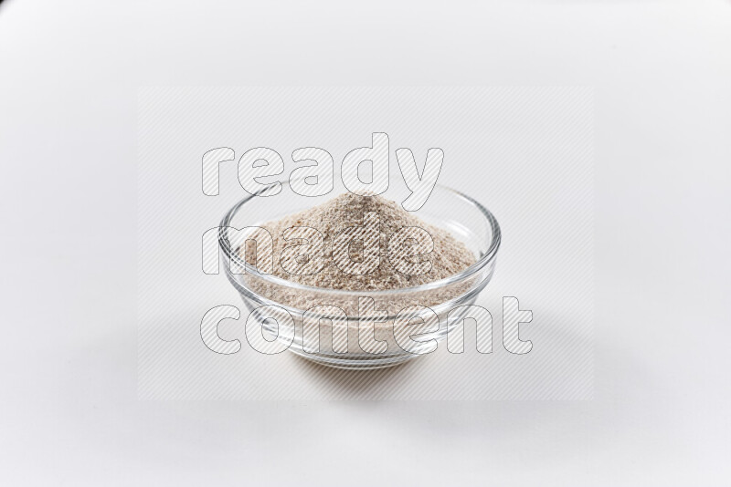 A glass bowl full of onion powder on white background