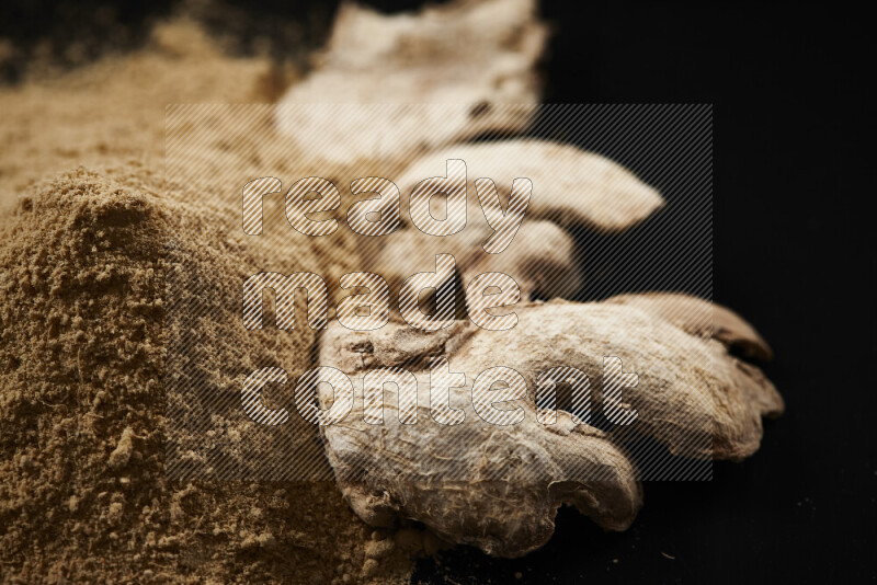 A bunch of ground ginger powder on black background